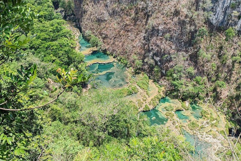 A river winding through a canyon with lush greenery and rocky cliffs. 1