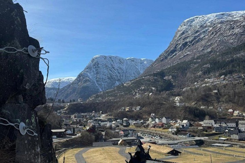 A mountainous landscape with a village, snow-covered peaks, and a clear sky. 4