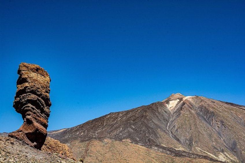 Un afloramiento rocoso y una montaña con cielo despejado. 1