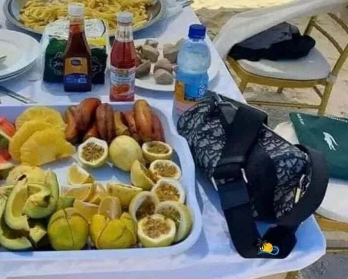 Una mesa con comida, bebidas y una mochila negra. 5