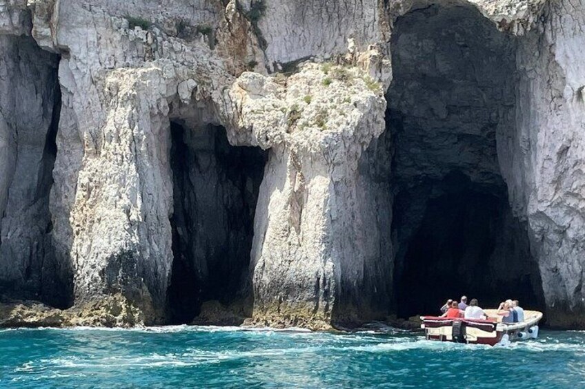 Ein Boot fährt auf einem schmalen Kanal zwischen steilen Felsen. 5
