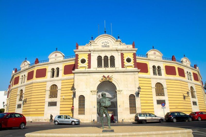 Ein großes, gelb-rotes Gebäude mit einer Statue davor. 3