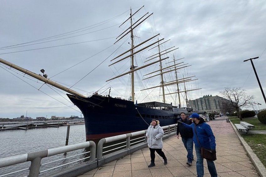 Un grand navire était amarré dans un port, et des gens se promenaient le long d’une passerelle située à proximité. 3