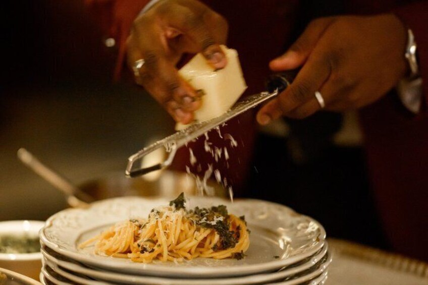 Une personne qui râpe du fromage sur une assiette de spaghettis. 4