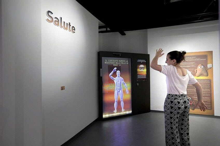 A person interacting with a digital display in an indoor setting. 3