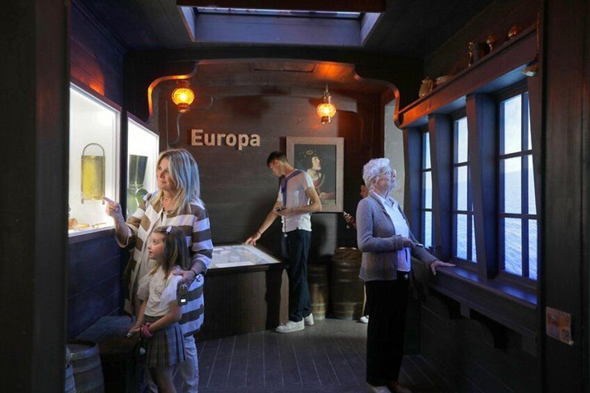 L'intérieur d'un train, avec une pancarte indiquant « Europa », un wagon-restaurant et une personne debout près d'une fenêtre. 1