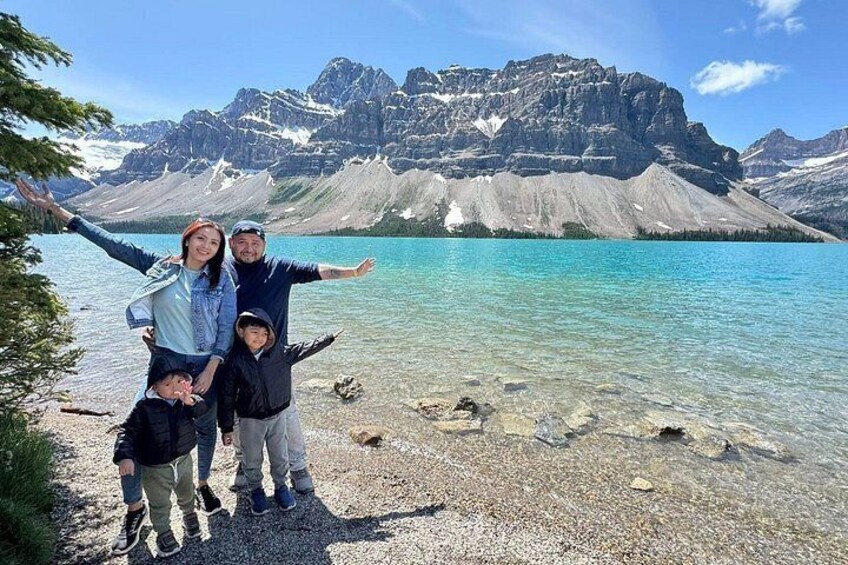 A family of four at a lakeside with mountains in the background. 3