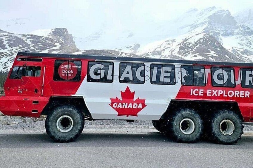 A red and white ice explorer vehicle with a Canadian flag and the words 'Glacier Tour' on its side. 1