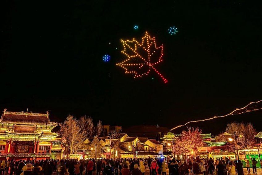 A traditional building with illuminated decorations, a crowd of people, and a large illuminated leaf structure in the sky. 4