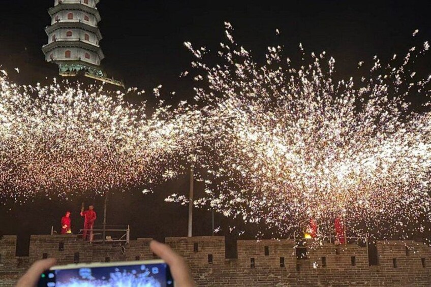 A pagoda, fireworks, and people on a brick wall. 3