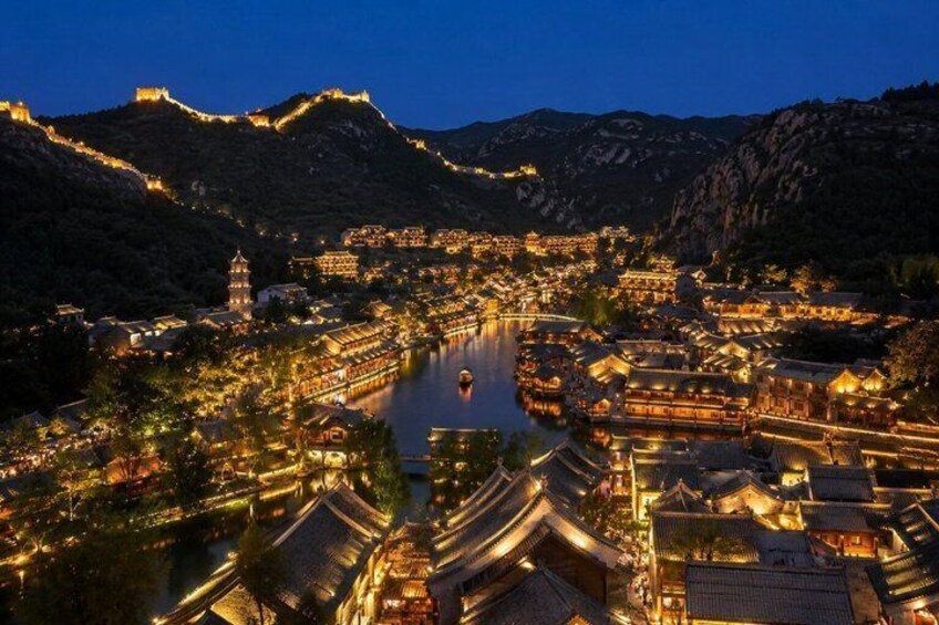 A historic town with traditional architecture by a river, surrounded by mountains. 5