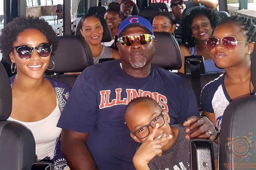 People seated in a bus with a man wearing a Chicago Bulls jersey. 5