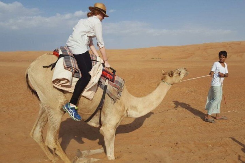A person riding a camel in a desert. 2