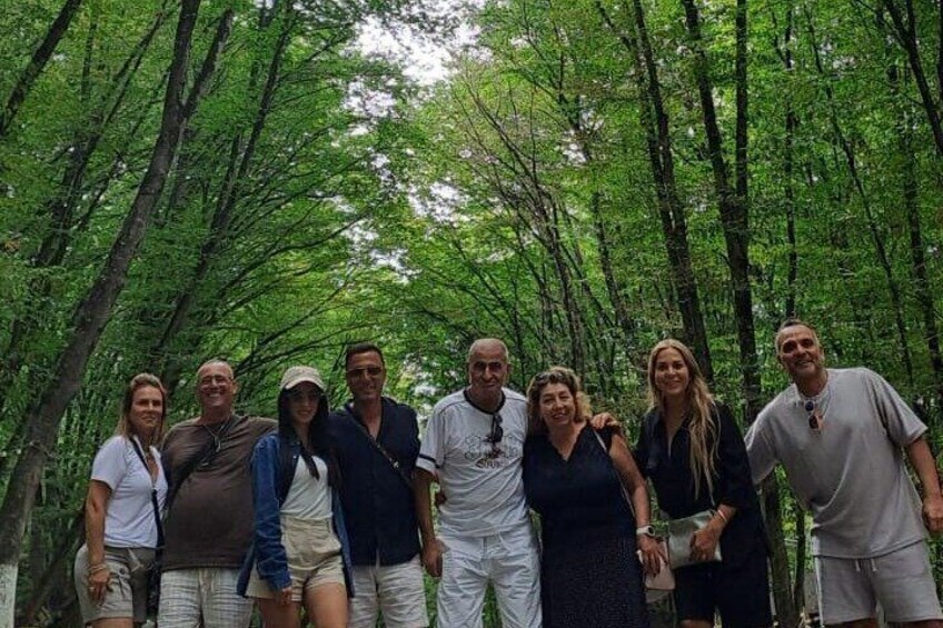 A group of people standing in a forested area. 3