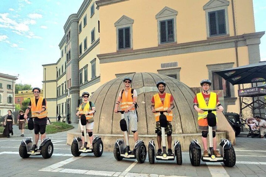 A group of people on segways in front of a building with classical architecture. 5