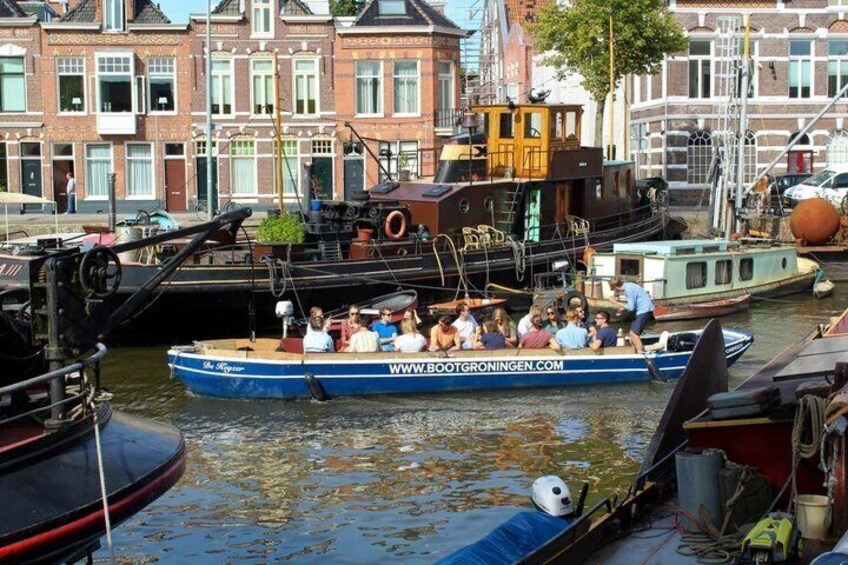 A canal with boats, a bridge, and buildings in the background. 2
