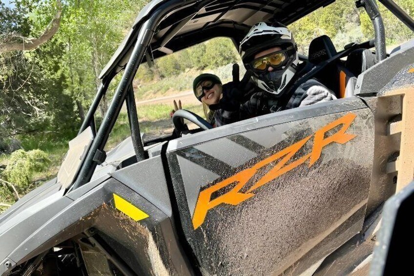 A vehicle with 'ROZR' branding, a person wearing a helmet, and a natural outdoor setting. 1