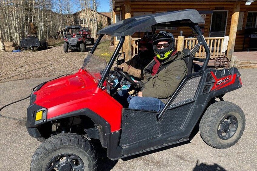 A red ATV with a driver wearing a helmet and jacket. 2