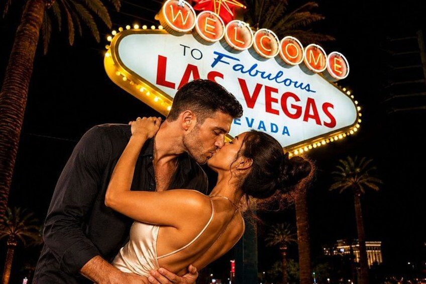 A couple kissing in front of the Las Vegas sign. 2