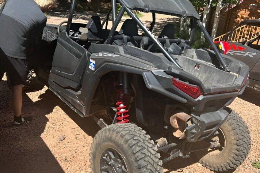 A black off-road vehicle with large tires and a spare tire mounted on the back. 4