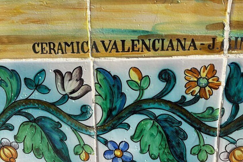 A ceramic tile with floral patterns and the text 'CERAMICA VALENCIANA - J. L.' 2