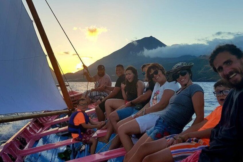 A group of people on a boat with a mountainous landscape in the background. 2