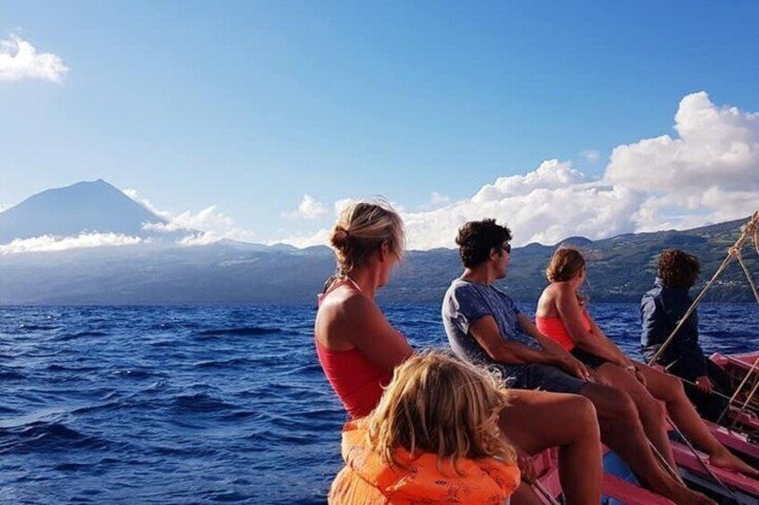 A group of people on a boat with a mountainous landscape in the background. 4