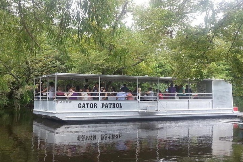 A boat named 'Gator Patrol' on a river surrounded by trees. 5