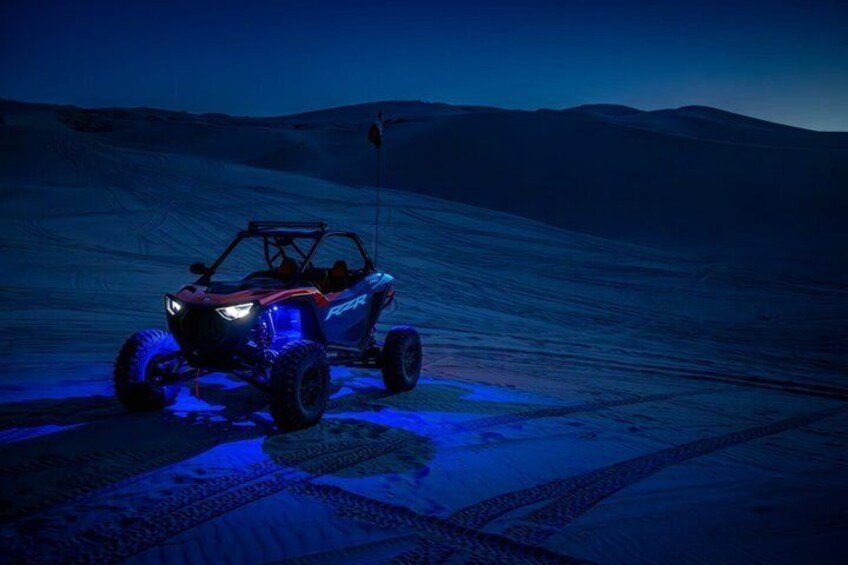 A Polaris RZR on a snowy terrain at dusk. 4