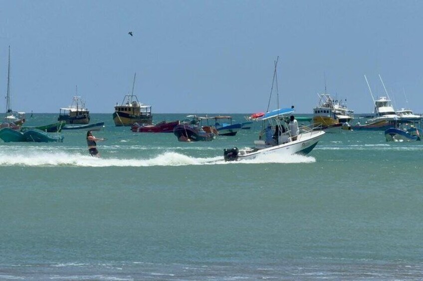 A busy marina with multiple boats and a jet ski in the water. 1