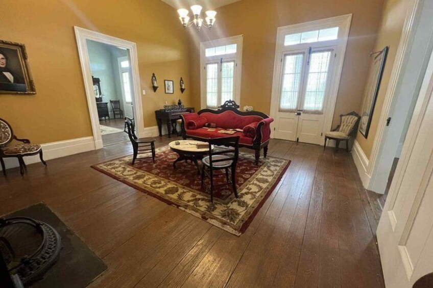 A living room with a red sofa, wooden floor, and a patterned rug. 4