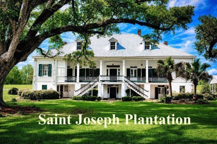 A large white plantation house with a porch, surrounded by lush green grass and trees. 2
