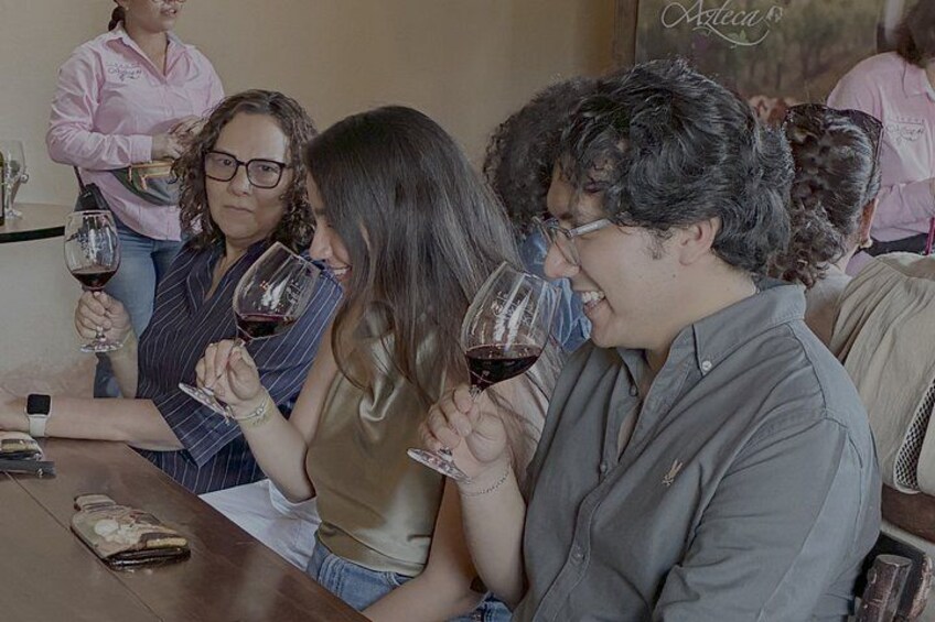 A group of people tasting wine at a table. 3