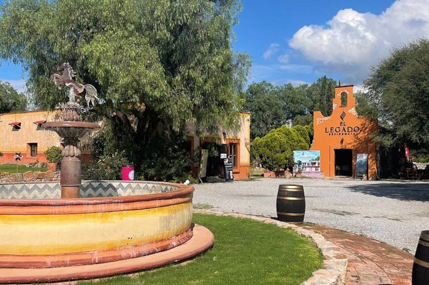 A fountain, a building labeled 'El Legado,' and a clear sky. 4