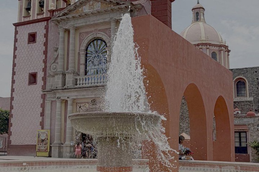 A historic building with a fountain in front. 2