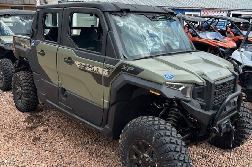 A rugged off-road vehicle with a camouflage pattern, large tires, and a winch. 1