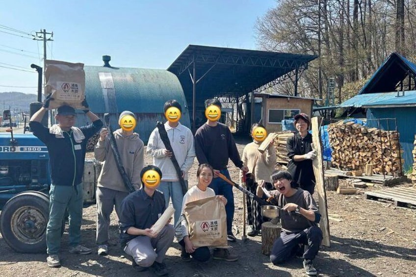 A group of people in an outdoor setting with a truck, a blue tarp, and a pile of logs. 1