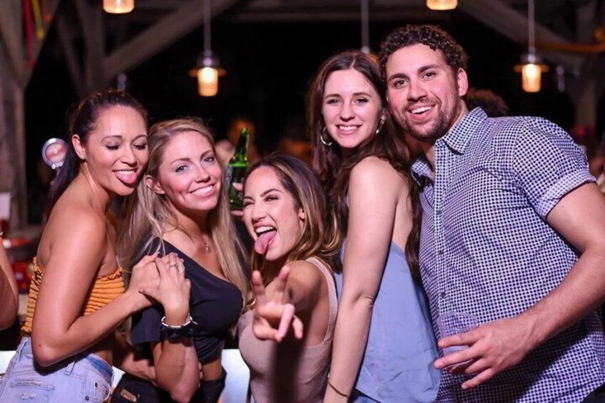 A group of people at a social gathering with hanging lights in the background. 3