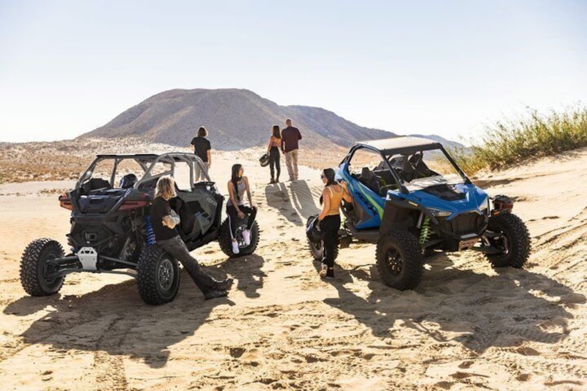 Two off-road vehicles on a sandy terrain with a mountainous background. 5
