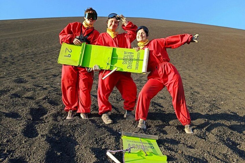 Three people in red suits holding a green object with numbers on it, standing on a barren landscape. 4