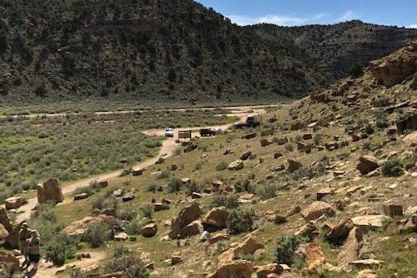 A rugged landscape with rocky terrain, sparse vegetation, and a winding dirt road. 4