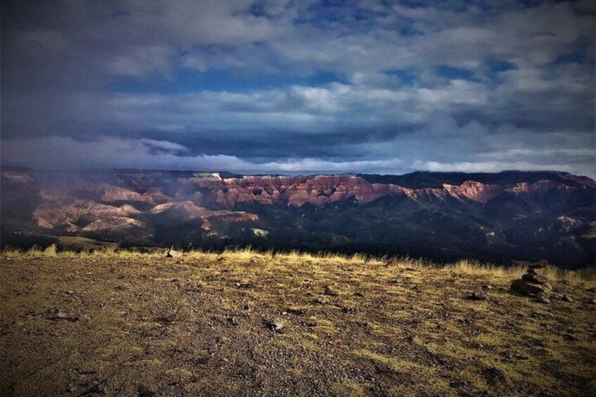 A mountainous landscape with a clear sky and a rock formation in the foreground. 2