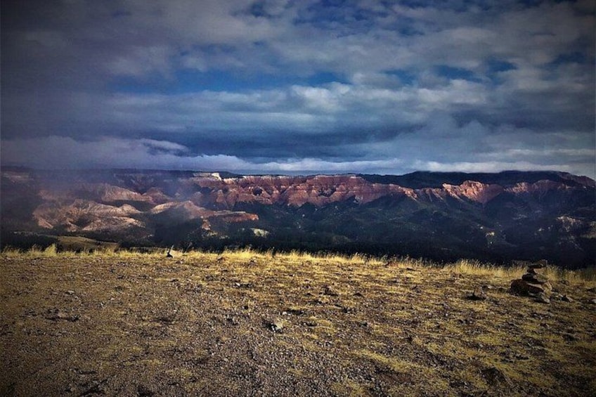 A mountainous landscape with a clear sky and a rocky foreground. 2
