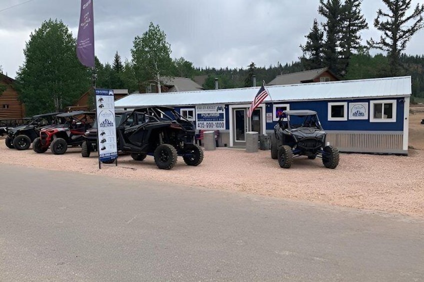 A building with an American flag, surrounded by off-road vehicles. 5