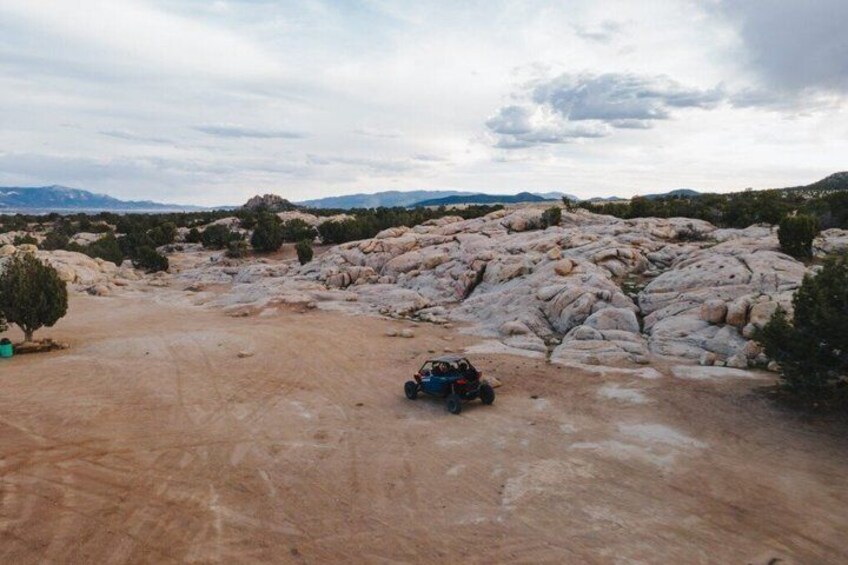 A remote rocky terrain with a vehicle and a person. 2
