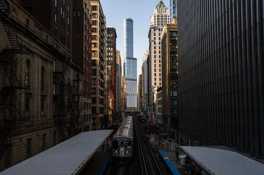 A train on tracks in an urban setting with tall buildings. 4