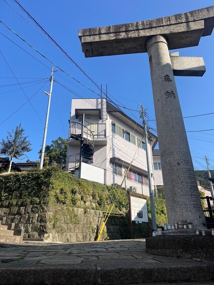 A stone monument with inscriptions, a modern building, and a stone staircase. 5