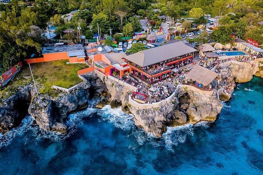 A coastal resort with a large building and a pool. 4