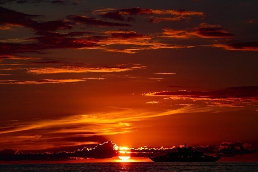 A sunset over a body of water with clouds. 3