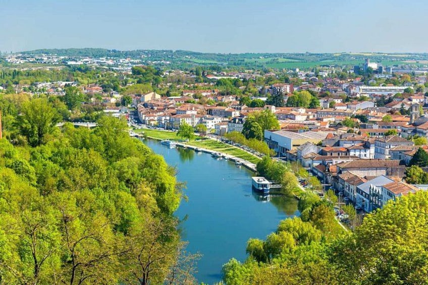 A river flowing through a town with buildings and greenery. 2
